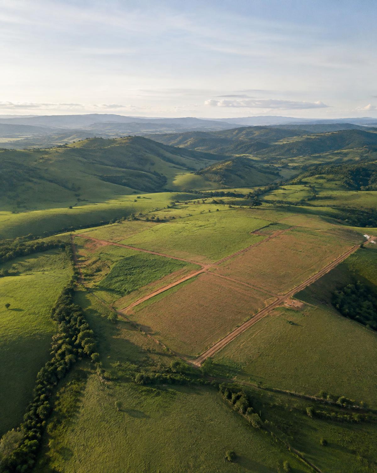 Vista aérea de terrenos entre colinas verdes